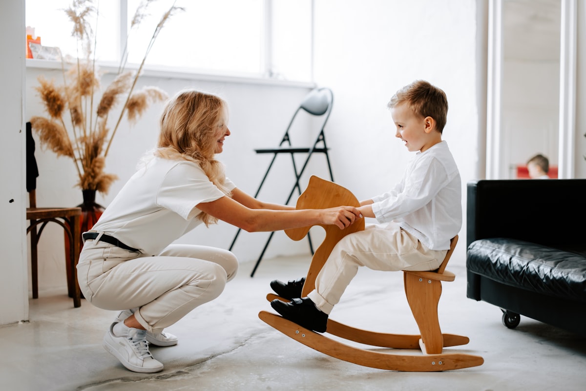 A caregiver crouching down to share a warm, playful moment with a young child
